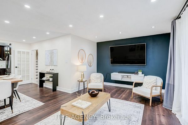 Living room with navy feature wall, laminate floors and a wall-mounted television